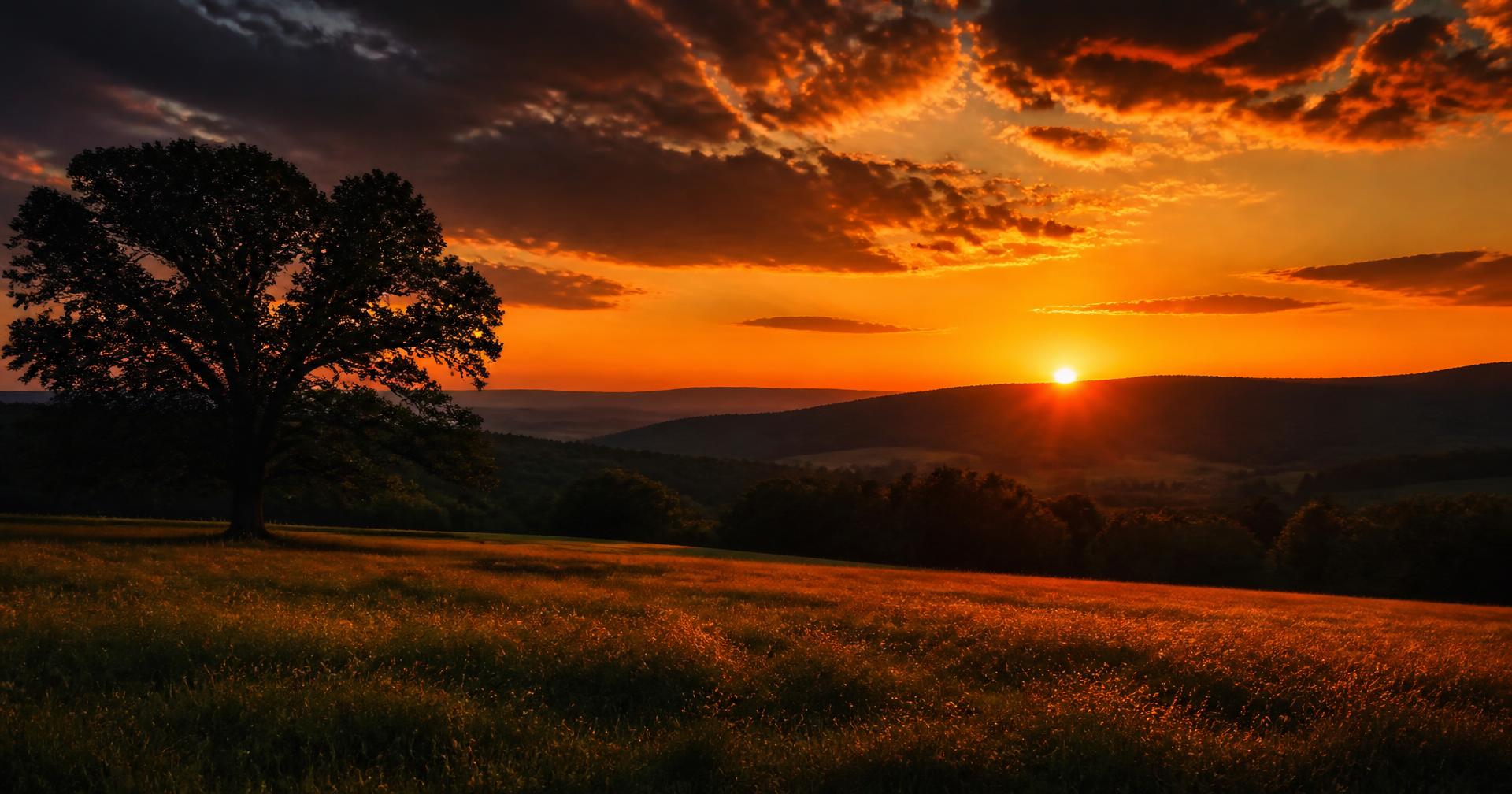 Dramatic Tennessee sunset over an open field and distant ridgeline